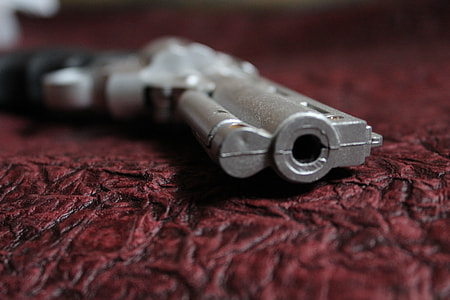 gray pistol on brown textile thumbnail