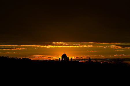 silhouette of structure under cloudy sky during sunset thumbnail