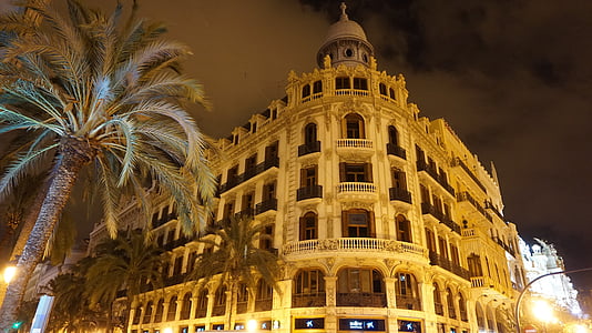 brown concrete building under gray sky during nighttime thumbnail
