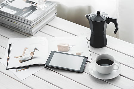 white ceramic teacup near black smartphone on table thumbnail