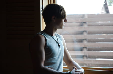 man standing beside the window thumbnail