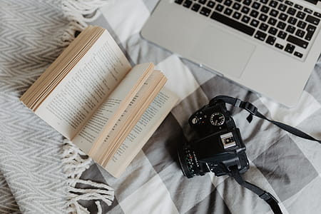 A camera, MacBook, and a book waiting in bed thumbnail
