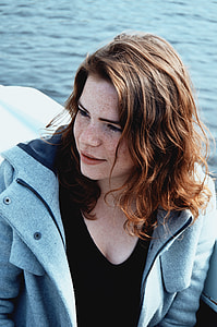 woman in white boat between body of water during daytime thumbnail