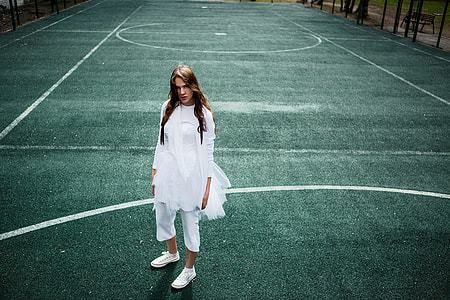 woman in white long-sleeve dress standing on field during daytime thumbnail