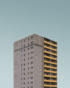 architectural photography of gray high-rise building under teal sky thumbnail