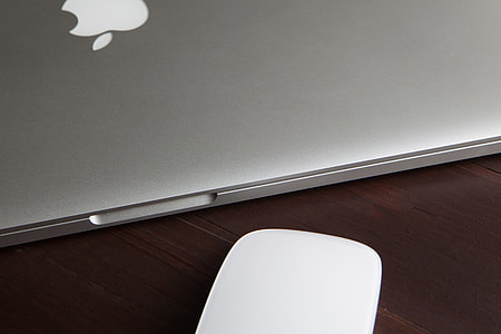 MacBook Pro laptop computer and Magic Mouse on a wooden desk thumbnail