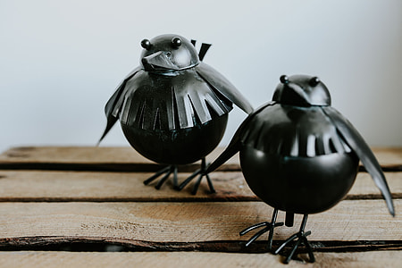 Little black plastic birds with a smartphone on a shelf thumbnail