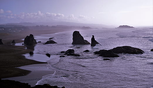 body of water with rock formation during day time thumbnail