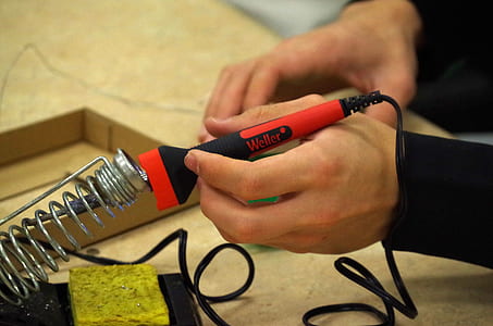 person holding soldering iron thumbnail