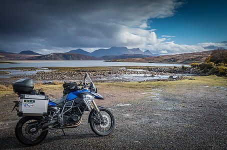 blue and white motorcycle park at daytime thumbnail