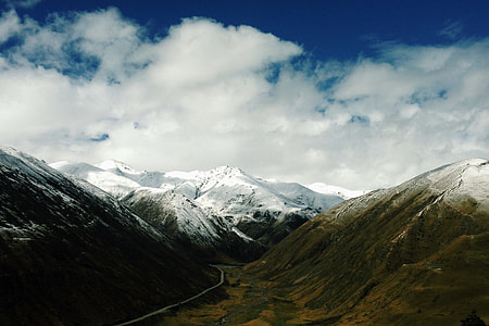 snow capped mountain under clouds and blue sky thumbnail