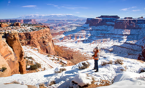 person standing on ice ground and facing at grand canyons thumbnail