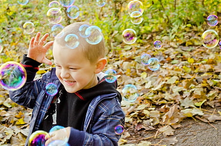 boy in plaid zip-up jacket playing bubbles thumbnail
