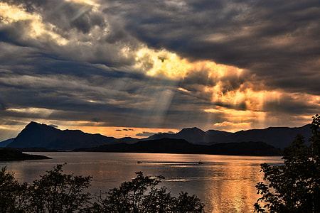 body of water across mountain during dawn thumbnail