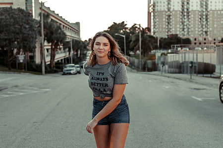 woman standing in the middle of road near buildings thumbnail