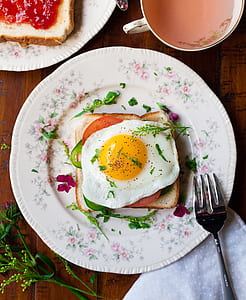 friend egg on bread on white ceramic plate beside stainless steel fork thumbnail