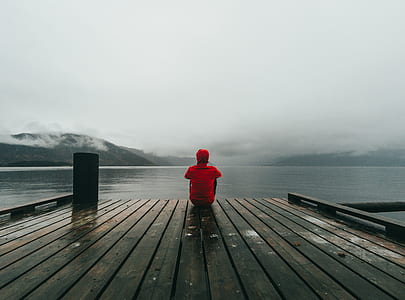man sitting in dock looking in the body of water thumbnail