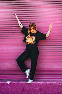 woman standing in front of pink roll-up door at daytime thumbnail