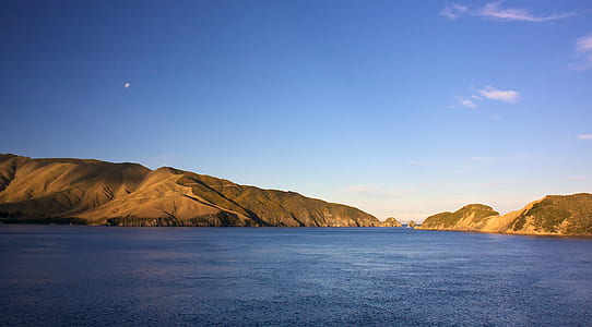 mountain beside ocean during daytime thumbnail