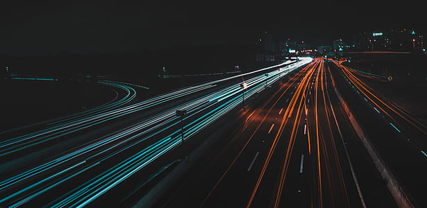 time lapse photography of vehicles crossing road at nighttime thumbnail
