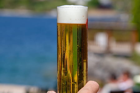 clear drinking glass with beer in tilt shift photography thumbnail