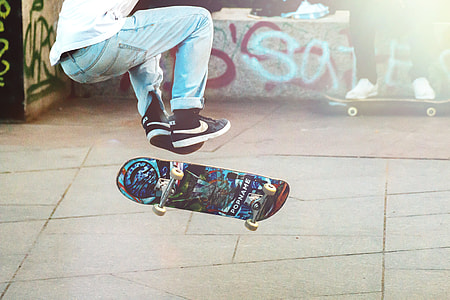 man playing blue and black skateboard during daytime thumbnail
