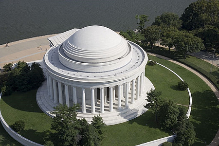 round white concrete building near body of water thumbnail