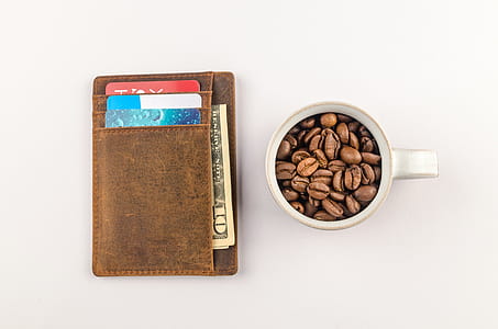 White Mug with Coffee Beans Beside Brown Wallet thumbnail