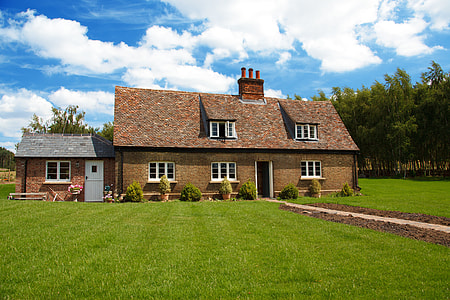 brown concrete house with green grass field at daytime thumbnail