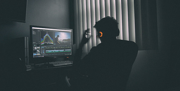 person sitting on chair while looking on computer monitor beside the window with window blinds during daytime thumbnail