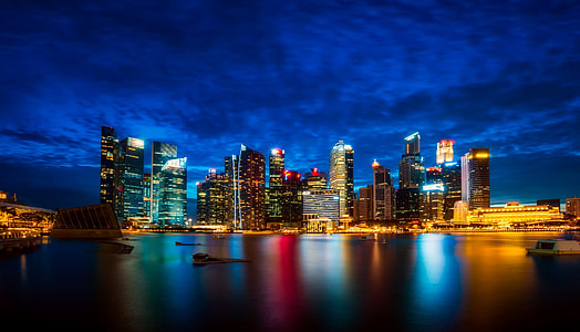 high rise building under blue sky near body of water thumbnail