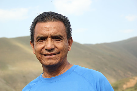 smiling man in blue crew-neck shirt thumbnail
