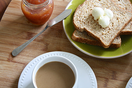 cup filled with coffee beside bread with jam thumbnail