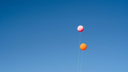 orange and pink balloons on the sky during daytime thumbnail
