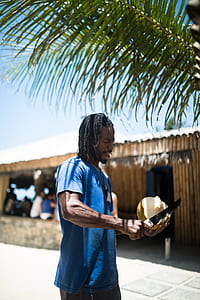 man holding coconut outdoor during daytime thumbnail