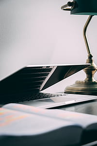 silver laptop computer beside lamp on table thumbnail