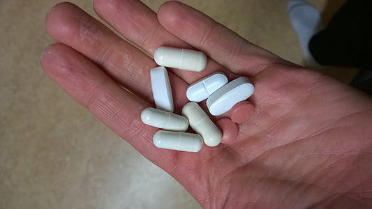 white capsules on hand thumbnail