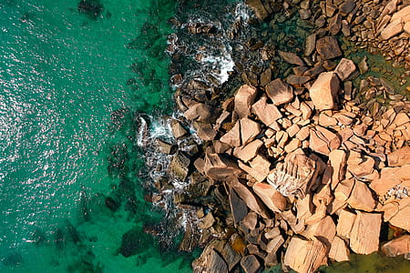 Bird's Eye View Photography of Rocks Near Body of Water thumbnail