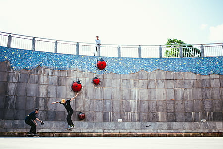 An onlooker watching one skateboarder being photographed by another in a skatepark thumbnail