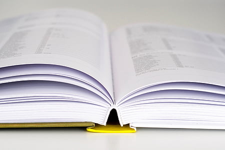 opened educational book on white surface thumbnail