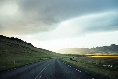 black asphalt road under dark cloudy sky thumbnail