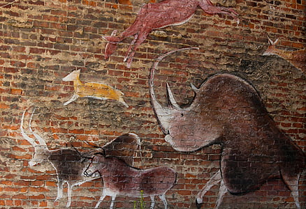 several assorted animals engraved on brown brick wall thumbnail