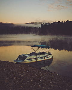 white and blue boat on body of water thumbnail