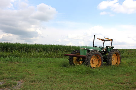 green tractor on green grass field at daytime thumbnail