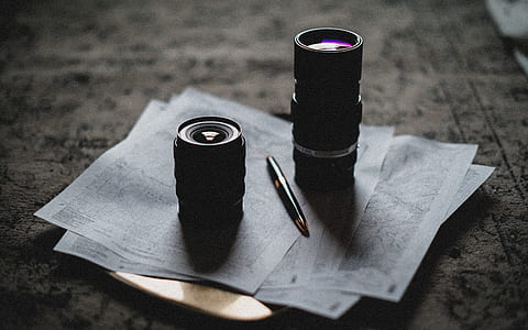 two black zoom lenses on gray printer paper next to fountain pen thumbnail