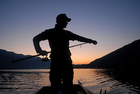 silhouette photograph of man fishing on lake thumbnail