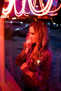 woman wearing blue denim jacket standing infront of clear glass thumbnail