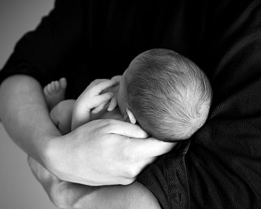 grayscale photo of person carrying baby thumbnail