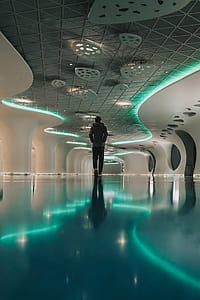 person in grey hoodie walking in middle of room thumbnail