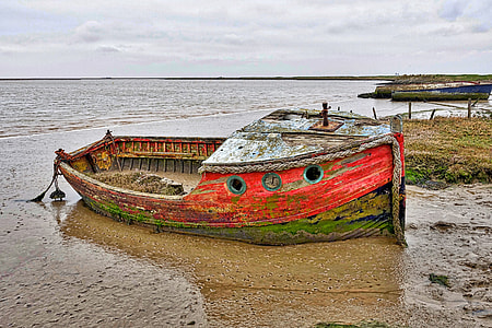 red wooden boat near body of water during daytime thumbnail